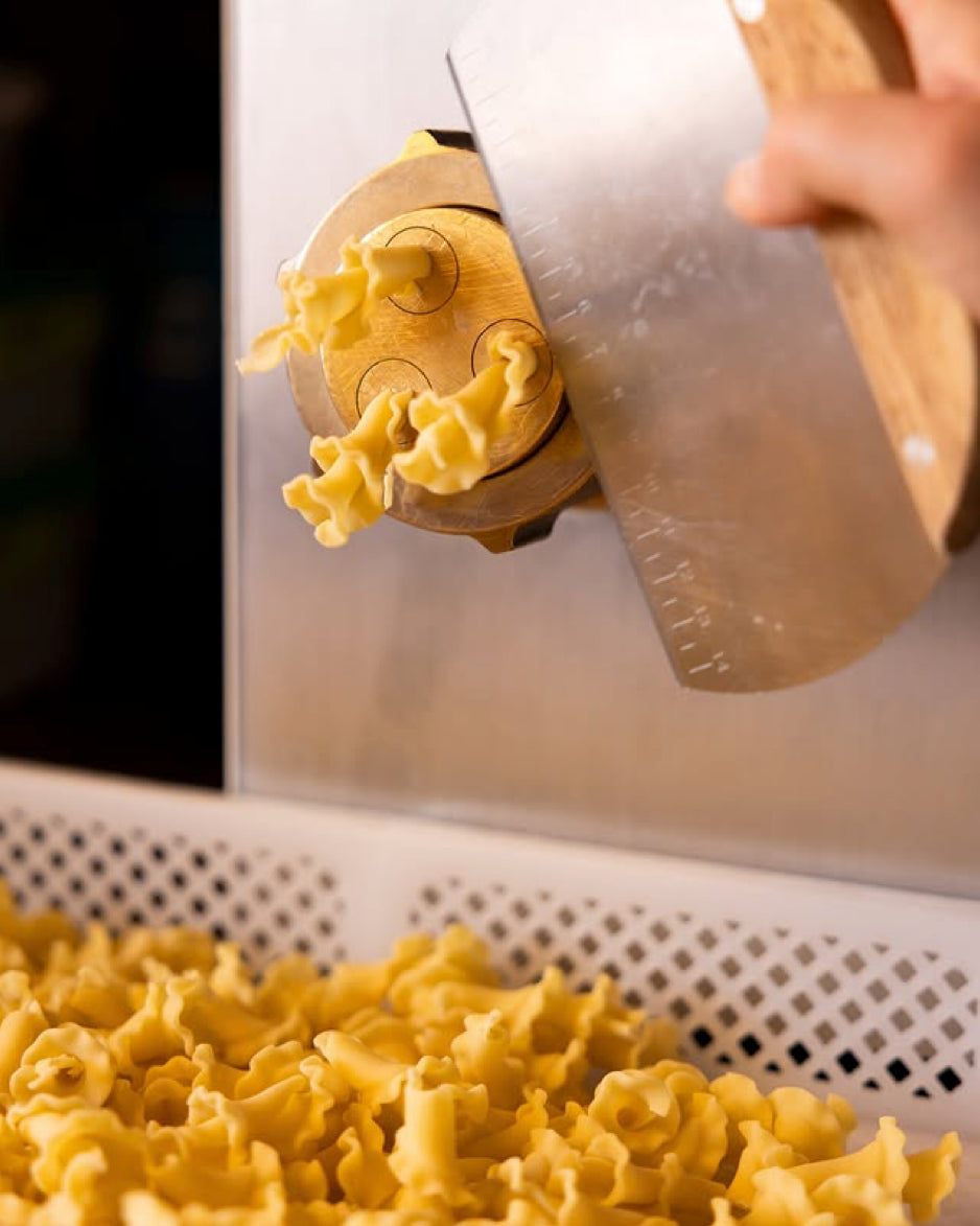 Short ruffled pasta shapes cut fresh from the bronze die at Pastaria Vivi's pasta counter